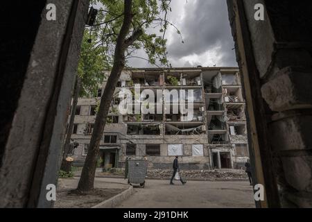 Kharkiv, Ukraine. 19th mai 2022. Les gens marchent à l'extérieur d'un immeuble d'appartements détruit des bombardements russes à Kharkiv, le mercredi 18 mai 2022. La Finlande et la Suède ont officiellement présenté des demandes d'adhésion à l'alliance militaire de l'OTAN au début de mercredi, mettant fin aux décennies de neutralité militaire des pays nordiques à la suite de la guerre de la Russie en Ukraine. Photo de Ken Cedeno/UPI crédit: UPI/Alay Live News Banque D'Images