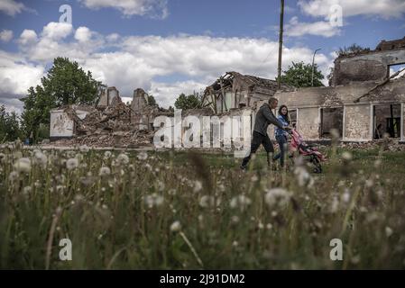 Merefa, Ukraine. 19th mai 2022. Un couple marche avec leur bébé par l'école secondaire de Merefa qui a été endommagé après que les Russes l'ont bombardé à Merefa, Ukraine, au sud de Kharkiv, mercredi, mai 18, 2022. La Finlande et la Suède ont officiellement présenté des demandes d'adhésion à l'alliance militaire de l'OTAN au début de mercredi, mettant fin aux décennies de neutralité militaire des pays nordiques à la suite de la guerre de la Russie en Ukraine. Photo de Ken Cedeno/UPI crédit: UPI/Alay Live News Banque D'Images