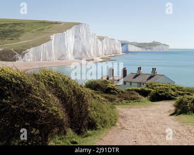 Les anciens chalets de la Garde côtière et les falaises de craie Seven Sisters juste à l'extérieur d'Eastbourne, Sussex, Angleterre, Royaume-Uni. Banque D'Images