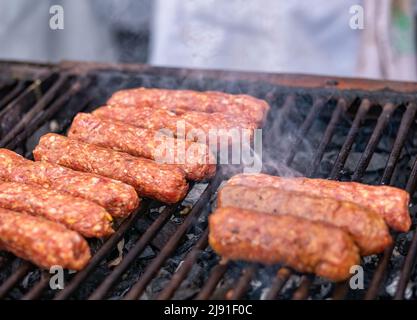 Mititei (petits pains de viande hachée) fait à partir d'un mélange de bœuf, d'agneau aux épices sur le gril. Plat traditionnel roumain Banque D'Images