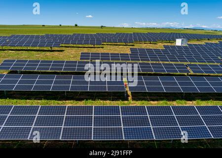 Vue aérienne les panneaux photovoltaïques se trouvent sur un terrain vert dans le nord de la Grèce. Ciel bleu réfléchissant dans les rangées de panneaux solaires. Station électrique alternative futuriste. S Banque D'Images