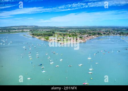 Photo aérienne de Bosham une destination de voile populaire dans le West Sussex, Angleterre avec des bateaux à voile ancrés dans l'estuaire pittoresque. Banque D'Images