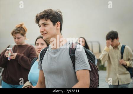 Des amis joyeux et multiethniques qui marchent à l'université Banque D'Images