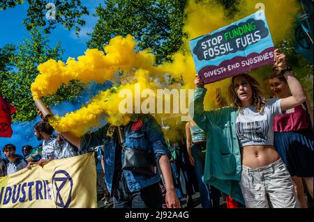 Rotterdam, pays-Bas, 19/05/2022, Une femme est vue en tenant une flamme jaune pendant la manifestation. Avec cette manifestation, l'organisation pour le climat, l'extinction Rebellion (XR), a lancé une campagne pour exiger la fin de l'industrie des fossiles et une transition vers un climat juste. Des centaines d'activistes se sont rassemblés à la gare centrale de Rotterdam, et de là ils ont défilé dans la ville, y compris plusieurs représentations artistiques. Cette campagne durera jusqu'au 24th mai et comptera sur plusieurs actions perturbatrices et des ateliers pour exiger une action d'urgence contre la crise climatique et écologique. Banque D'Images