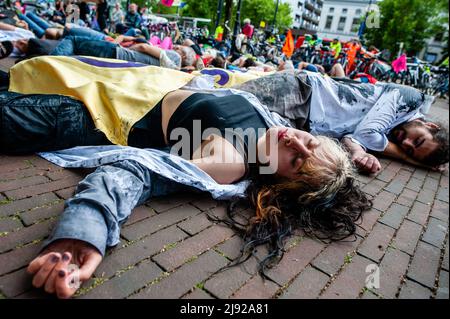 Rotterdam, pays-Bas, 19/05/2022, Un activiste du climat se trouve sur le terrain, prétendant être mort pendant la manifestation. Avec cette manifestation, l'organisation pour le climat, l'extinction Rebellion (XR), a lancé une campagne pour exiger la fin de l'industrie des fossiles et une transition vers un climat juste. Des centaines d'activistes se sont rassemblés à la gare centrale de Rotterdam, et de là ils ont défilé dans la ville, y compris plusieurs représentations artistiques. Cette campagne durera jusqu'en mai 24th et comptera sur plusieurs actions perturbatrices et des ateliers pour exiger une action d'urgence contre le climat et l'écologie Banque D'Images