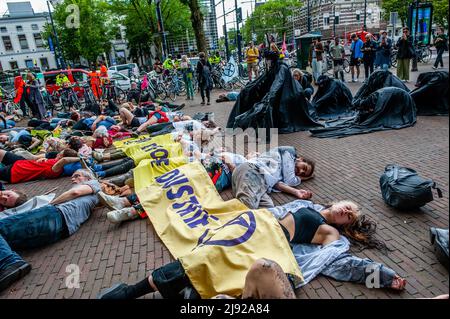 Rotterdam, pays-Bas, 19/05/2022, les rebelles noirs (des gens vêtus de vêtements noirs) sont vus regardant les activistes se poser sur le terrain pendant la manifestation. Avec cette manifestation, l'organisation pour le climat, l'extinction Rebellion (XR), a lancé une campagne pour exiger la fin de l'industrie des fossiles et une transition vers un climat juste. Des centaines d'activistes se sont rassemblés à la gare centrale de Rotterdam, et de là ils ont défilé dans la ville, y compris plusieurs représentations artistiques. Cette campagne durera jusqu'au 24th mai et comptera sur plusieurs actions perturbatrices, et des ateliers pour exiger emerg Banque D'Images