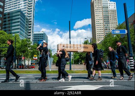 Rotterdam, pays-Bas, 19/05/2022, Un groupe d'activistes vu portant un cercueil qui représente la mort de mère Terre pendant la manifestation. Avec cette manifestation, l'organisation pour le climat, l'extinction Rebellion (XR), a lancé une campagne pour exiger la fin de l'industrie des fossiles et une transition vers un climat juste. Des centaines d'activistes se sont rassemblés à la gare centrale de Rotterdam, et de là ils ont défilé dans la ville, y compris plusieurs représentations artistiques. Cette campagne durera jusqu'au 24th mai et comptera sur plusieurs actions perturbatrices et des ateliers pour exiger une action d'urgence contre Banque D'Images