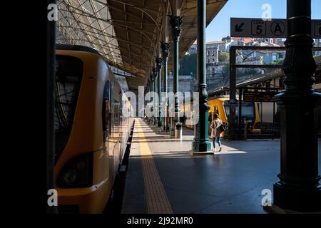 Prenez le train à São Bento avec le panneau Line 5 - Linha 5 - et une fille marchant seule jusqu'au train à une gare vide de Porto, au Portugal. Banque D'Images
