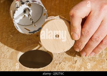 Travailleur avec fraise en action à l'atelier. Menuisier faisant des trous dans la planche de bois. BRICOLAGE Banque D'Images