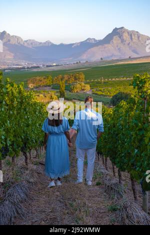 Paysage de vignoble au coucher du soleil avec des montagnes à Stellenbosch, près du Cap, Afrique du Sud. Raisins de vin sur la vigne dans un vignoble, couple homme et femme marchant dans Vineyard à Stellenbosch Afrique du Sud Banque D'Images
