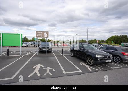 Panneau de stationnement pour les parents et les tout-petits au parking du supermarché Morrisons et icône peinte sur le sol dans l'espace de stationnement Banque D'Images