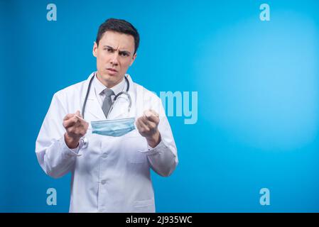 Médecin sérieux avec masque médical en studio Banque D'Images