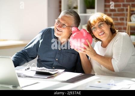 Jeune Homme recherche femme à l'insertion d'une pièce de monnaie pour Piggybank Banque D'Images