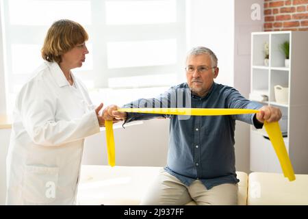 Patient en physiothérapie utilisant des bandes de physiothérapie pour la réadaptation Banque D'Images