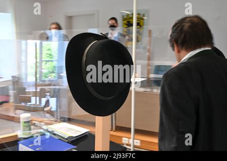 Ravensburg, Allemagne. 20th mai 2022. Le chapeau d'un fruitier défendeur (r) est suspendu au poste d'une partition dans la salle d'audience du tribunal du travail. Les travailleurs géorgiens de la récolte ont intenté une action en justice contre la ferme fruitière pour des retenues salariales. Le cas porte essentiellement sur la question de savoir si les travailleurs de la récolte ont droit au salaire minimum même si l'employeur ne les utilise pas, par exemple, en raison du mauvais temps. Credit: Felix Kästle/dpa/Alay Live News Banque D'Images