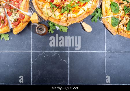 Trois pizzas variées, servies à la maison ou au restaurant sur une table carrelée avec des ingrédients de cuisine, tomate, basilic, épinards, pizza classique à l'arugula pepperoni Banque D'Images