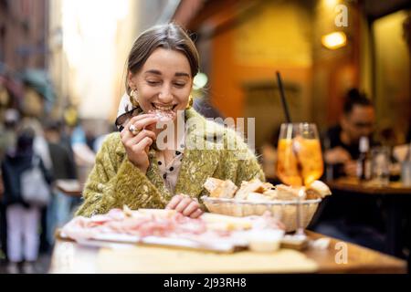 Femme avec des en-cas italiens et des boissons au bar à l'extérieur Banque D'Images