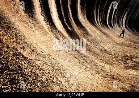 Personne debout dans l'incroyable Wave Rock d'Australie occidentale. Banque D'Images