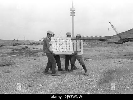 ARCHIVE PHOTO: Il y a 50 ans, le 26 mai 1972, le Stade Olympique de Munich a été ouvert, 01SN Grundstein140769SP.jpg pose de la pierre de fondation des Jeux Olympiques de Munich 1972 sur le site olympique Oberwiesenfeld de Munich; pour le Stade Olympique salle olympique Radstadion salle olympique de natation; Quatre ouvriers de la construction tiennent la pierre de fondation avec l'inscription 'Pierre de fondation des bâtiments pour les jeux de la XXXe Olympiade 1072 à Munich le 14 juillet 1969'; paysage ; plan noir et blanc ; Â Banque D'Images