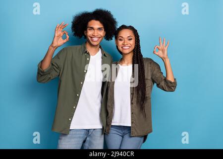 Photo de deux partenaires gais les doigts de la main montrent le symbole de clé isolée sur fond bleu Banque D'Images