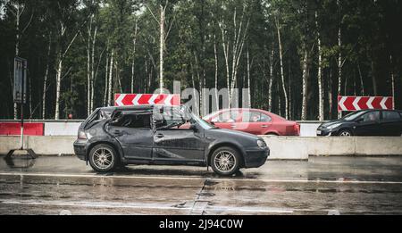 2012: voiture à hayon noir s'est complètement écrasé après le shunt avec un camion en raison de la dérive sur route humide et rétrécie Banque D'Images
