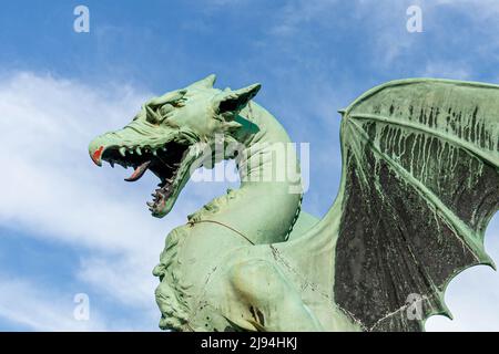 Ljubljana, Slovénie - 07.15.2021 : une sculpture en bronze du dragon sur fond bleu, en regardant à gauche Banque D'Images