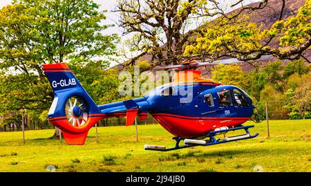 G-GLAB bleu et rouge - Airbus Helicopter H135 hovers en préparation au décollage, APPLECROSS Peninsula, Bealach na Ba, North Coast 500, Écosse Banque D'Images