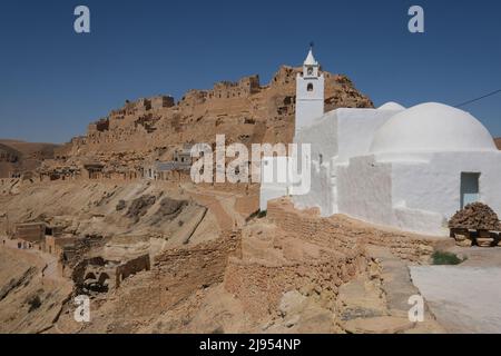 Vue sur une mosquée blanche à Chenini, ville déserte de la vieille ville berbère, au sommet d'une colline, en Tunisie . Un village berbère ruiné dans le district de Tataouine, Tunisie Banque D'Images