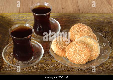 Pâte fourrée ou farcie au sésame et deux verres de thé noir en plateau, pâte au sésame connue sous le nom de « kombe » à Hatay, Turquie. Banque D'Images