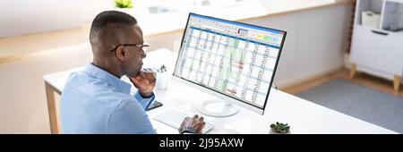 Employé analyste travaillant avec la feuille de calcul sur ordinateur Banque D'Images