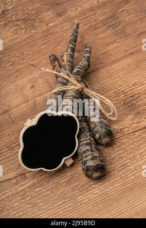 quelques carottes rouges avec un tableau noir sur une table en bois Banque D'Images