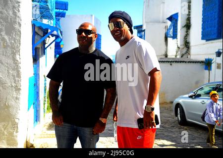 Sidi Bou dit, Tunis, Tunisie. 20th mai 2022. Ronaldinho à Sidi Bou Said (ville touristique au nord de Tunis) ancien joueur de Paris Saint Germain, FC Barcelone et AC Milan. Vainqueur de la coupe du monde avec le Brésil en 2002 et ballon d'Or 2006 en Tunisie à partir de mai 19. C'est l'artiste K2Rym(L) qui l'a annoncé dans une vidéo publiée sur sa page Facebook officielle.l'objectif de la visite de Ronaldinho est de ''promouvoir le tourisme et le patrimoine tunisien'' et de montrer au monde que la Tunisie est toujours une destination sûre.photo de Yassine Mahjoub. (Credit image: © Chokri Mahjoub/ZUMA Press Wire) Banque D'Images