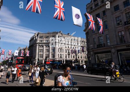 Les drapeaux de l'Union pendent au-dessus d'Oxford Street tandis que les amateurs de shopping, les visiteurs et les Londoniens passent à côté pour célébrer le Jubilé de platine de la reine Elizabeth IIS le 17th mai 2022 à Londres, au Royaume-Uni. En 2022, sa Majesté la Reine Elizabeth II deviendra le premier monarque britannique à célébrer un Jubilé de platine à l'occasion de l'anniversaire de son accession au trône le 6 février 1952, en 70th. Oxford Street est un grand centre de détail dans l'extrémité ouest de la capitale et est la rue commerçante la plus animée d'Europes avec environ un demi-million de visiteurs par jour dans ses quelque 300 boutiques, dont la majorité sont Banque D'Images