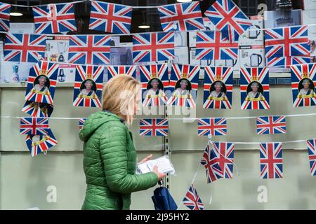 Londres, Royaume-Uni, 20 mai 2022. . Un piéton passe devant les banderoles Union Jack exposées dans une vitrine à Wimbledon, dans le sud-ouest de Londres, en prévision des célébrations du Jubilé de platine pour reconnaître les 70 années de service de la reine Elizabeth II comme le plus long monarque britannique au service. Le week-end central du Jubilé de platine a lieu du 2nd au 5th juin avec des événements à travers le Royaume-Uni .Credit. amer ghazzal/Alamy Live News Banque D'Images