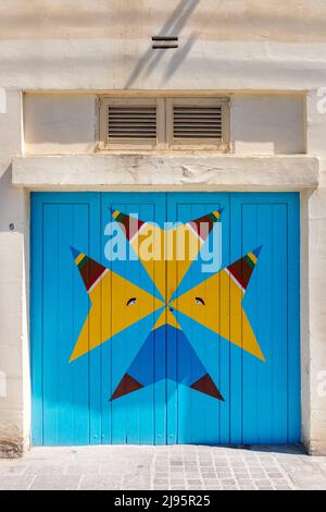 Croix maltaise aux couleurs traditionnelles des bateaux de pêche, Marsaxlokk, Malte Banque D'Images