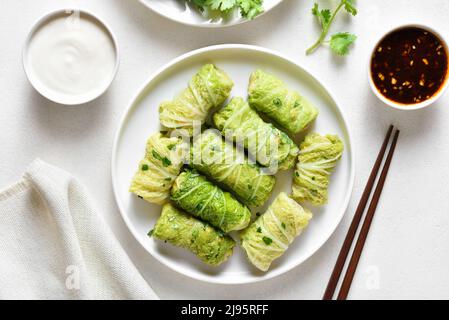 Des rouleaux de chou farcis de style chinois sur fond de pierre blanche.Vue de dessus, plan d'appartement Banque D'Images