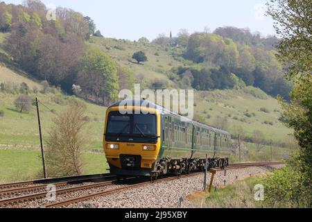 Un train traversant de beaux paysages dans les collines de Surrey, le jour du soleil, avec une église sur la colline en arrière-plan Banque D'Images