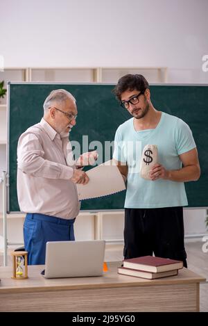 Vieux professeur et jeune étudiant dans le concept de rémunération Banque D'Images