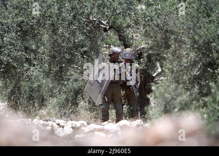 Naplouse, Palestine. 12th mai 2022. Des soldats israéliens visant les manifestants palestiniens, lors de la manifestation contre les colonies israéliennes dans le village de Kafr Qaddoum, près de la ville de Naplouse, en Cisjordanie. Crédit : SOPA Images Limited/Alamy Live News Banque D'Images