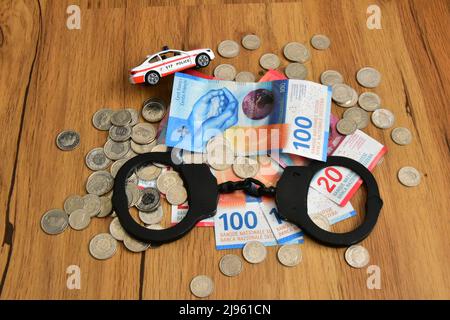 argent suisse avec menottes et jouet voiture de police Banque D'Images