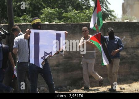 12 mai 2022, Naplouse, Cisjordanie, Palestine : les manifestants palestiniens brûlent le drapeau israélien devant les soldats israéliens lors de la manifestation contre les colonies israéliennes dans le village de Kafr Qaddum près de la ville de Naplouse, en Cisjordanie. (Credit image: © Nasser Ishtayeh/SOPA Images via ZUMA Press Wire) Banque D'Images