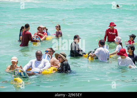 Miami Beach Florida, Sabrina Cohen Adaptive Beach Day, handicapés besoins spéciaux roues d'eau handicapées fauteuil roulant flottant, hispanique Noir homme homme femme Banque D'Images