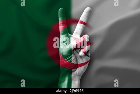 Main faisant le V signe de victoire avec le drapeau de l'algérie Banque D'Images