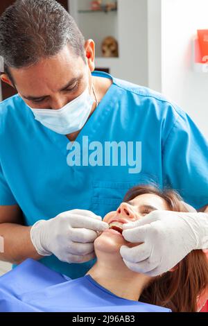 Belle femme recevant un traitement orthodontique au cabinet de dentiste Banque D'Images