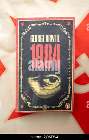Calgary (Alberta) - le 20 mai 2022 : couverture de la 1984 de George Orwell sur fond de drapeau communiste. Banque D'Images