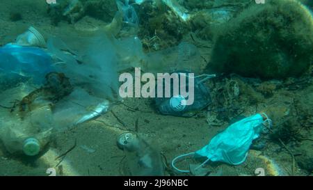 Mer Adriatique, Monténégro. 26th mars 2019. Les poissons morts de grande taille (Trachinus draco) qui frappent piégés dans un sac en plastique se trouvent à l'intérieur d'un sac en plastique sur le fond marin, parmi le masque médical, le plastique et d'autres déchets. Pollution plastique de l'océan. (Credit image: © Andrey Nekrasov/ZUMA Press Wire) Banque D'Images