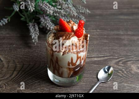 Dessert tiramisu avec fraises et sauce au chocolat dans un verre Banque D'Images