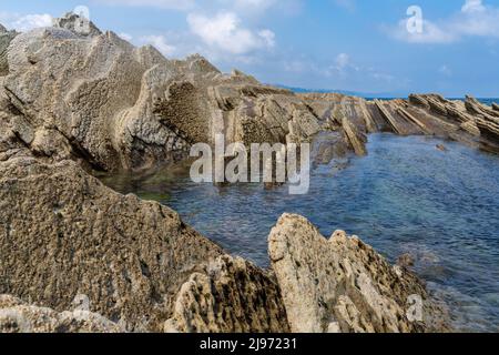 Vue sur les formations rocheuses et les bassins de marée de Flysch sur la côte basque près de Zumaia Banque D'Images