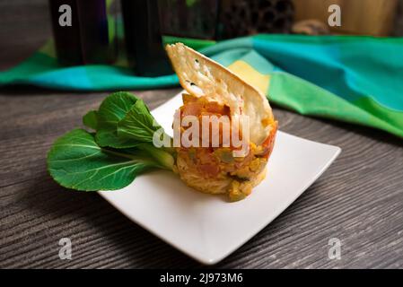 Escalope de poulet avec tomate épicée et relish aux olives. Décoration avec tranche mince de crouton, jeune pak choi frais. Anneau à salade utilisé pour former un plat. Banque D'Images