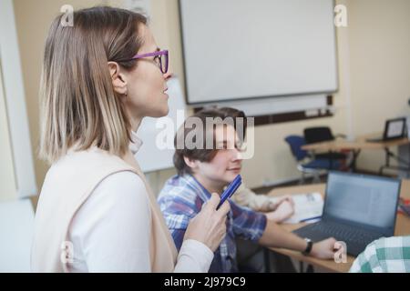 Gros plan d'un professeur mature enseignant des étudiants de collège Banque D'Images